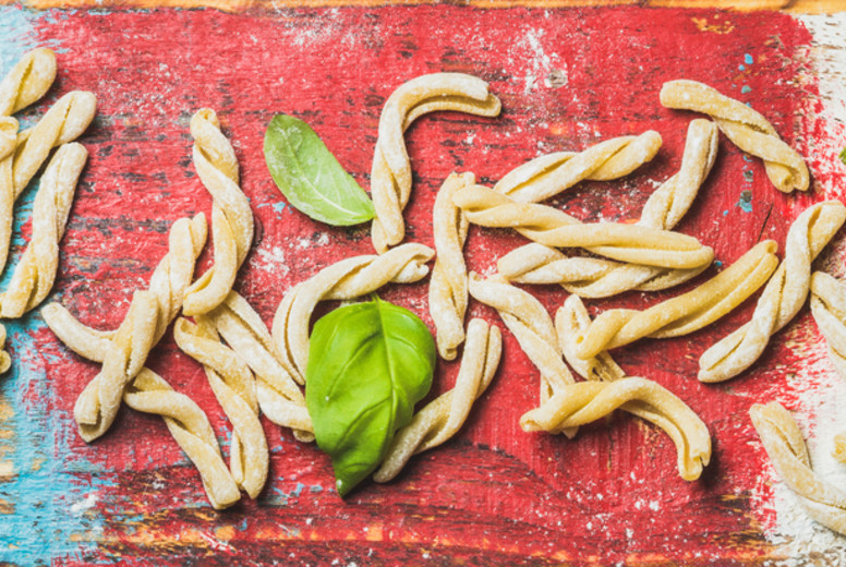 Homemade uncooked pasta casarecce with flour and green basil leaves