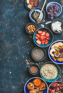 Ingredients for healthy breakfast in bowls over plywood background