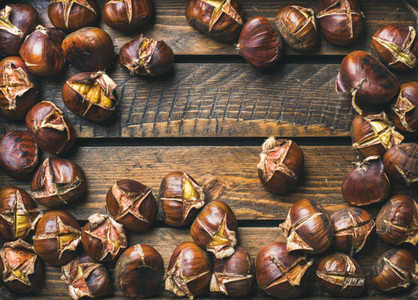 Close up of roasted chestnuts over rustic wooden background