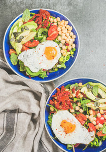 Healthy breakfast bowls with fried egg  chickpea sprouts  seeds  greens