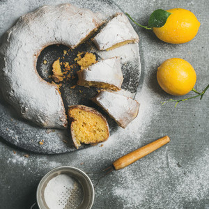 Homemade gluten free lemon bundt cake over grey concrete background