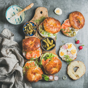 Variety of bagels with vegetables salmon and cream cheese