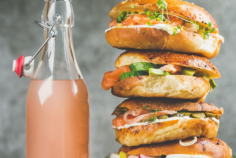 Heap of bagels with salmon, eggs, vegetables, capers, cream-cheese, lemonade