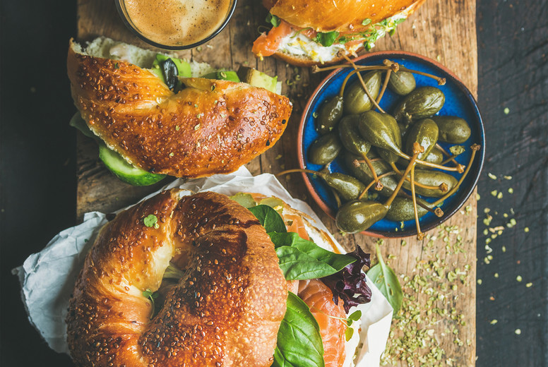 Breakfast with bagel, espresso coffee, capers on board, top view