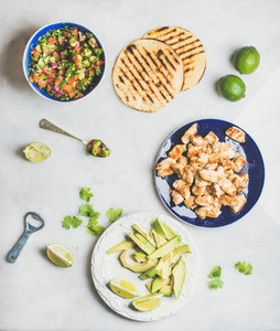 Ingredients for cooking chicken and avocado tacos  grey marble background