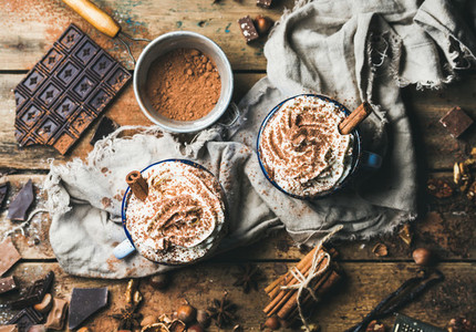 Hot chocolate with whipped cream cinnamon nuts and cocoa powder