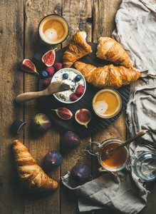 Breakfast with croissants ricotta figs fresh berries honey and espresso