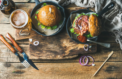 Beef burgers with crispy bacon vegetables glass of beer