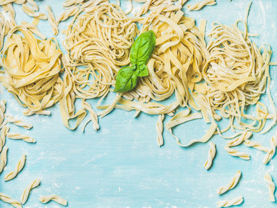 Various homemade fresh Italian pasta with flour and  basil