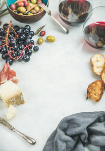 Red wine and snack set over grey marble background