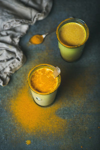 Golden milk with turmeric powder in glasses  energy boosting drink