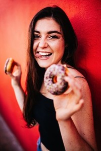 Woman eating chocolate donuts