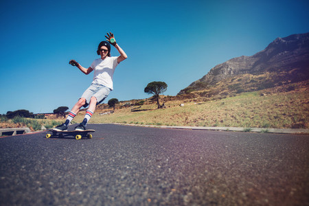 Young man longboarding on a road