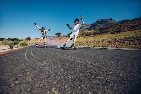 Young people skateboarding with smoke bomb on the road