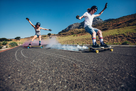 Young people longboarding down the road