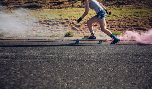 Young woman longboarding down the road