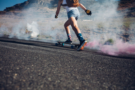 Young woman skateboarding on a road