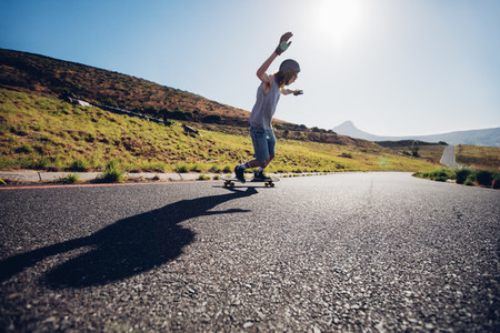 Young man skateboarding down the road