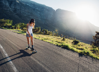 Young woman skating outdoors on rural road