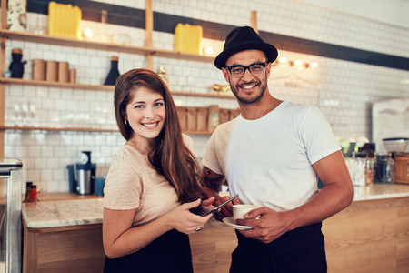 Young couple at cafe with a cup of coffee and digital tablet