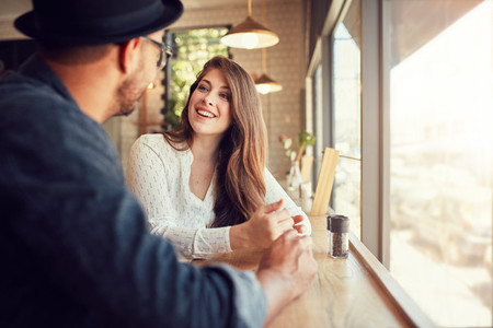 Smiling young woman at cafe with her boyfriend