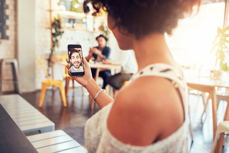Woman having a videochat with man on mobile phone