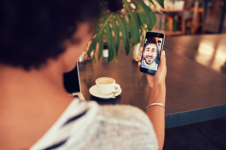 Woman having a videochat with friend on mobile phone