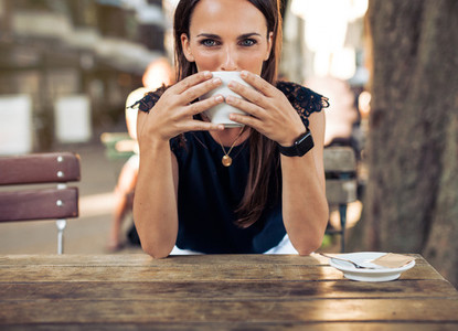 Young woman drinking coffee at a cafe
