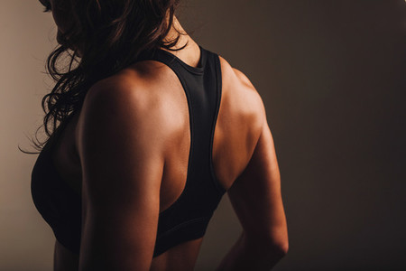 Muscular back of a woman in sportswear
