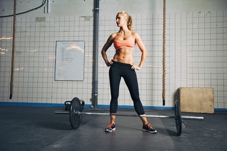 Strong crossfit female at gym with barbells