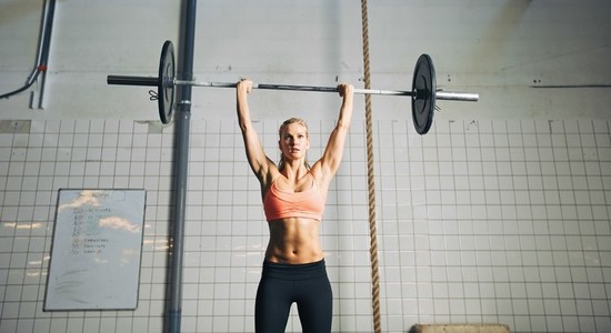 Fitness woman lifting barbells