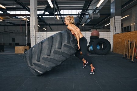 Fit female athlete flipping a huge tire