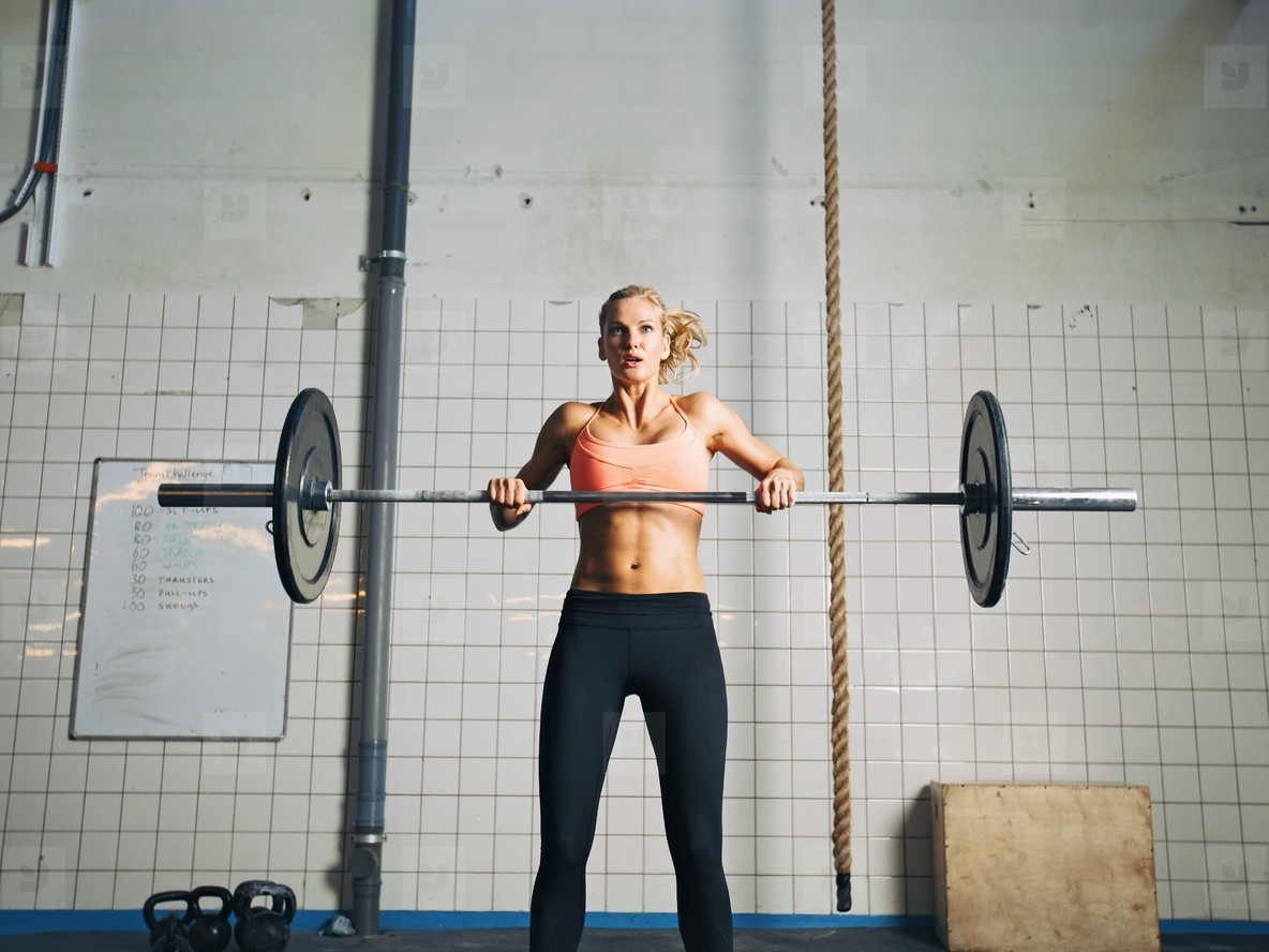 Crossfit young woman lifting heavy weights