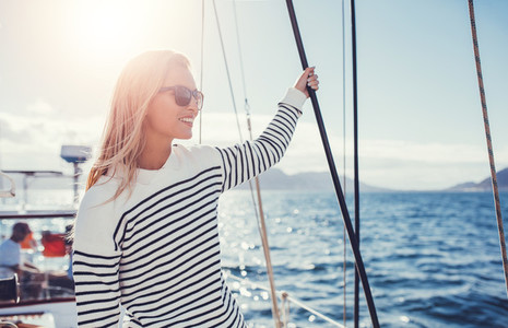 Woman on sailboat enjoying a beautiful day on vacation