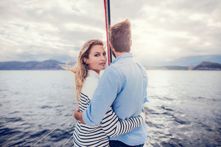 Young couple on vacation standing on a boat