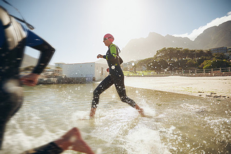 Participants running into the water for start of a triathlon