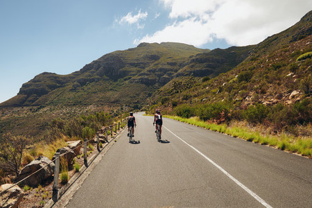 Triathletes practicing cycling on open country road