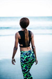 Back view of woman in sports wear at beach
