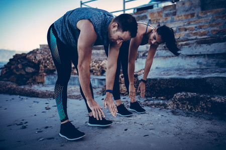 Young athlete couple doing stretching exercise together