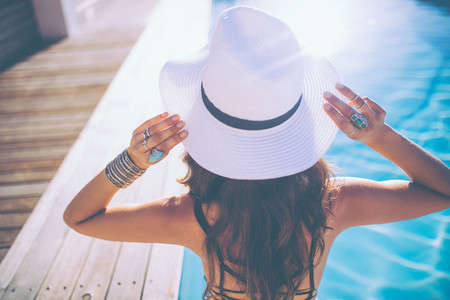 Back view of attractive woman wearing a summer hat