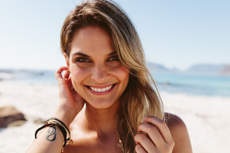 Beautiful young woman smiling on the beach