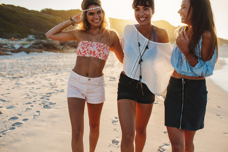 Stylish young women walking on a beach