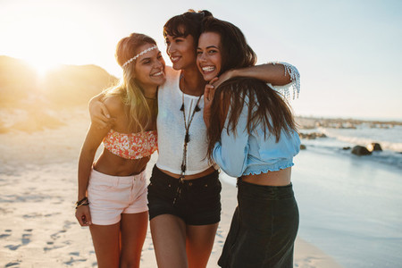 Female friends walking together at the beach
