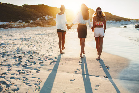 Three friends walking on the beach