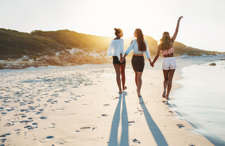 Young females walking along the beach on a summer day