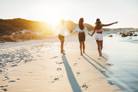 Young women strolling along a beach and enjoying