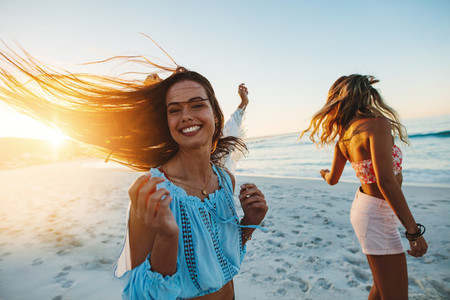 Female friends dancing on the beach