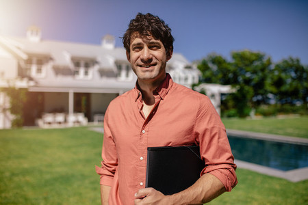 Real estate agent standing outside a home for sale