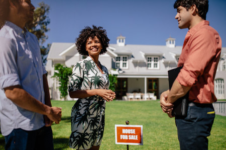 Couple with real estate agent visiting house for sale