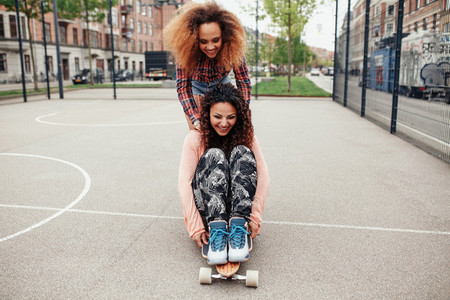 Young women skating in a basketball court